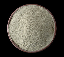 Ashwagandha powder pile in clay pot (Withania somnifera) isolated on black, top view