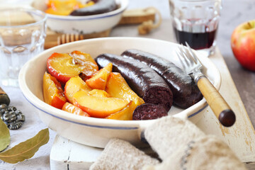 Traditional French cuisine: fried blood sausage and apples
