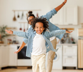 Happy funny african american family excited little boy son having fun with father at home