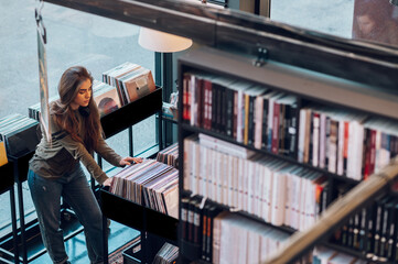Woman choosing vinyl record in music record shop