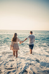 Happy couple by the sea. Honeymoon lovers. Man and woman on the island. Beautiful couple having fun on the seashore. Happy couple on vacation. Man and woman by the sea.