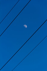 Big white moon between power lines
