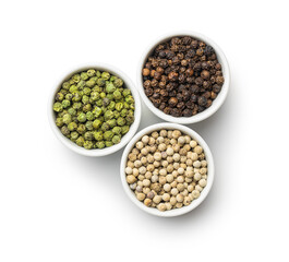 Three different types of pepper spice. Green, white and black peppercorn in bowls.