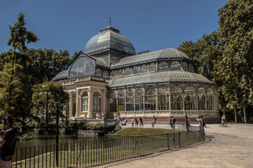 Fototapeta na wymiar Photograph of the Crystal Palace in Parque del Retiro in Madrid with a sky full of clouds
