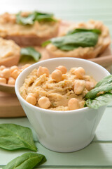Bowl with healthy hummus on table