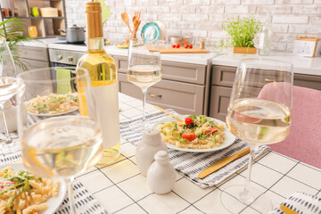 Table setting with tasty pasta and wine at home