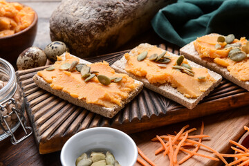 Crispbreads with tasty carrot hummus on table