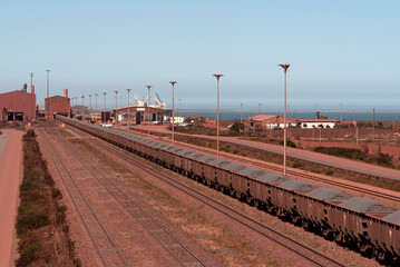 Fototapeta na wymiar Saldanha Bay, West Coast, South Africa. 2022. Railway trucks carrying iron ore from Sishen to Saldanha Bay terminal on the West Coast of South Africa.
