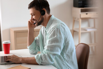 Consultant of call center with headset working in office