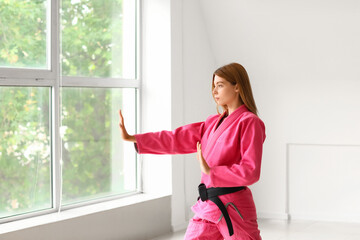 Fototapeta na wymiar Young woman practicing karate in gym