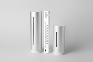 Home weather station and thermometer on white background