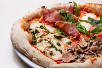 delicious italian pizza with tomatoes, ham, salami, cheese on a white background