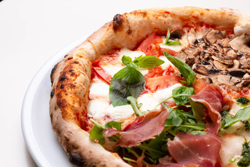 delicious italian pizza with tomatoes, ham, salami, cheese on a white background