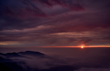 SOL AL ATARDECER ENTRE LAS NUBES Y EL HORIZONTE