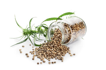 Bottle with hemp seeds on white background