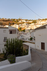 White houses illuminated at dawn on the slopes of the mountain in the famous town of Setenil de las Bodegas, Cadiz province, Andalusia, Spain