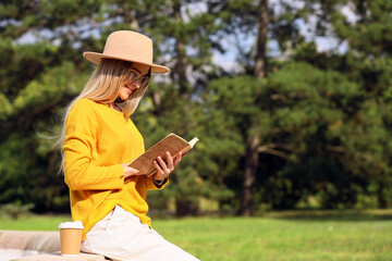 Beautiful woman reading book in park