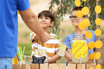 Cute children selling lemonade in park - obrazy, fototapety, plakaty