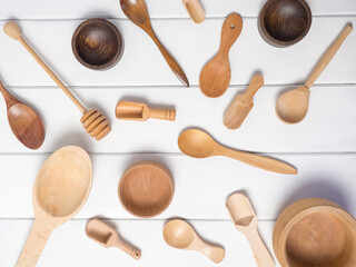 Still life of household kitchen utensils on a white wooden table. Top view, wooden cutlery