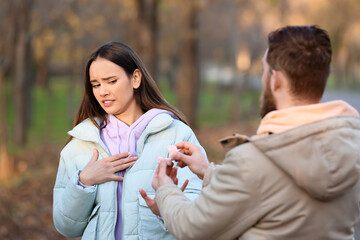 Obraz premium Young woman rejecting marriage proposal from her boyfriend in forest