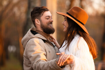 Young woman with engagement ring and her fiance in park