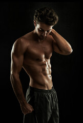 Fototapeta premium Dedication = Super body. Gorgeous man with a sculpted body isolated on black.