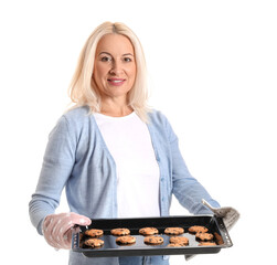 Mature woman holding baking dish with cookies on white background