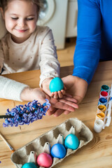 the family paints colorful Easter eggs. mom, dad and daughter celebrate spring holiday together