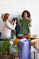 Young women at swap home party - clothes, shoes, bags, jewellery exchange between friends. Zero waste shopping, eco friendly concept, sustainable lifestyle. College life