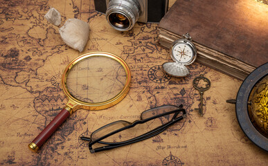 Fototapeta na wymiar Vintage travel concept shown with old map and magnify glass, pocket compass