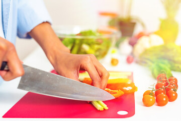 Woman in the home kitchen prepares a genuine salad with fresh vegetables