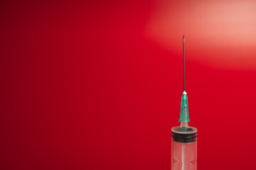 syringe on a red background