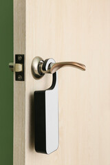 Wooden door with hanger in hotel room, closeup