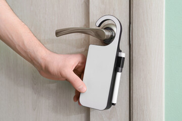 Man with door hanger in hotel room, closeup