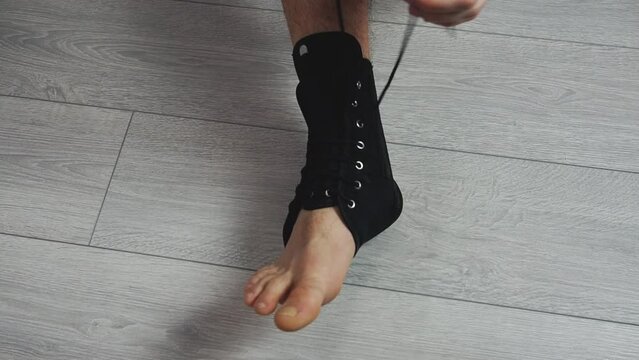 Applaying compression ankle stabilizer bandage. Leg injury and sprain of young sports man 