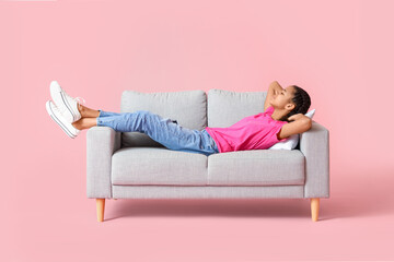 Obraz premium African-American teenage girl relaxing on sofa against color background