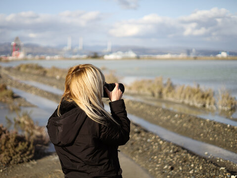 Girl taking pictures nature beach spring winter blue sky