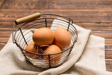 Basket with fresh chicken eggs on wooden background
