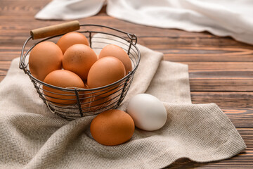 Basket with fresh chicken eggs on wooden background