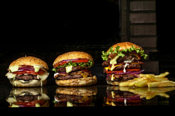 tres hamburguesas con panes especiales , todo a la parrilla  sobre la mesa