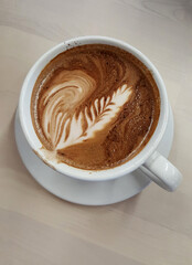 Coffee mug filled with a latte on a wooden table