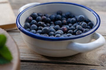 blueberries in old vintage bowl on wooden background