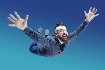 A middle-aged man with a beard and an unusual hairstyle falls down from a great height. Men with Mohawk and dreadlocks in flight