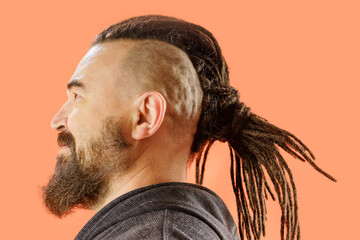 Artificial dreadlocks. A middle-aged man with a beard and an unusual hairstyle. Adult male with...