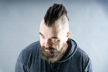 Challenging appearance. A middle-aged man with a beard and an unusual hairstyle. Adult male with...