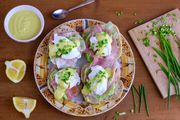 Kanapki z jajkiem w koszulce, szynką, sałatą i szczypiorkiem polane sosem. Jajka po benedyktyńsku © Monika