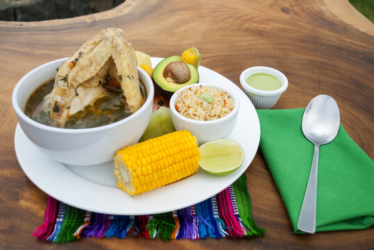Delicious chicken broth lunch served outdoors on wooden table, natural light, typical dish