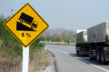 Yellow traffic sign  to warn  truck driver to drive carefully down to hill on slope a steep 8 percent(8%) downhill gradient beside the road.  Concept : Traffic Road Sign and symbol.