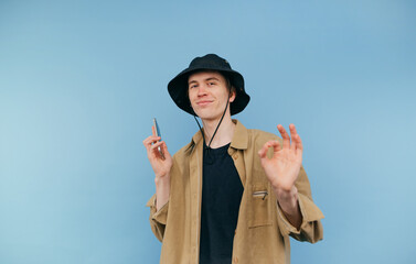 Funny guy shows a gesture of a shot to the head with a finger weapon and looks at the camera with a...