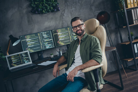 Portrait of attractive cheery skilled guy developing web project intranet remote support at work workplace workstation indoors